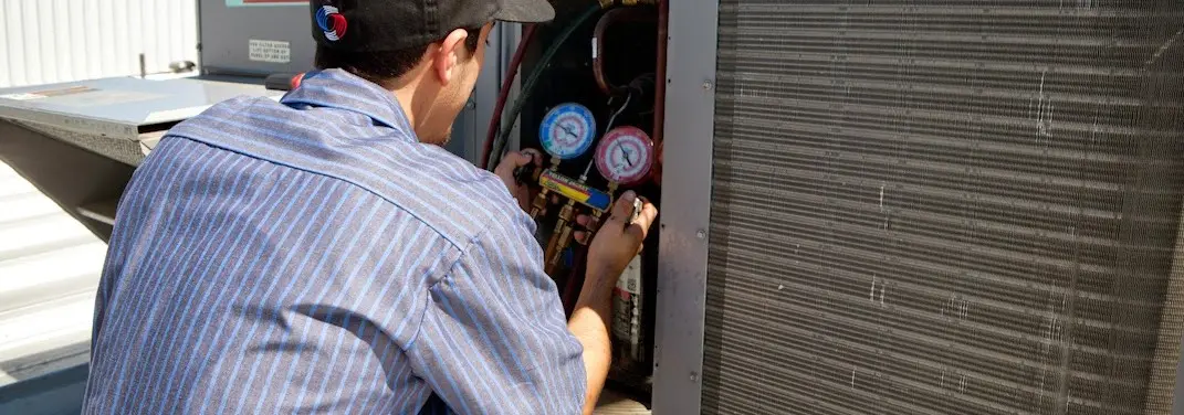 HVAC technician servicing a condenser unit in Pine Hill