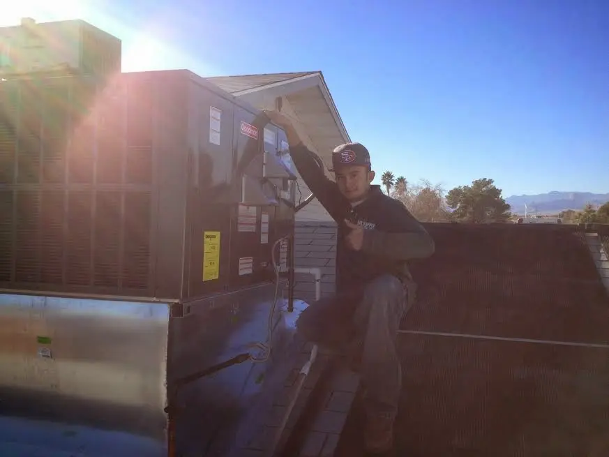HVAC technician performing Boiler Repair on a rooftop unit in Pine Hill